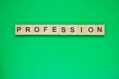 Kelime oyunu. Ahşap bloklar ve yeşil arka planda harfler. Yeşil yüzeyde harfleri olan tahta blokların üst görünümü