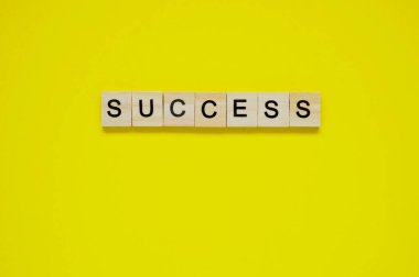 Kelime başarısı. Sarı arka planda harfleri olan tahta bloklar. Sarı yüzeyde harfleri olan tahta blokların üst görünümü