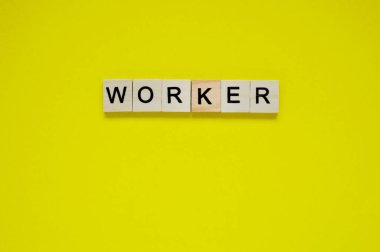 Sözcü. Sarı arka planda harfleri olan tahta bloklar. Sarı yüzeyde harfleri olan tahta blokların üst görünümü