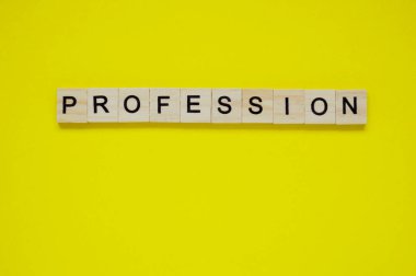 Kelime oyunu. Sarı arka planda harfleri olan tahta bloklar. Sarı yüzeyde harfleri olan tahta blokların üst görünümü