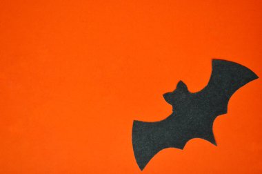 Siyah kağıt yarasa turuncu bir zeminde yatıyor.