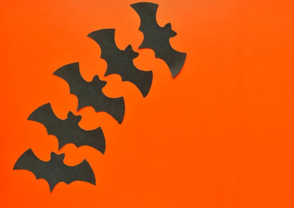 黑纸蝙蝠躺在橙色的背景上 — 图库照片