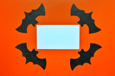 Siyah kağıt yarasalar turuncu arka planda yatar.