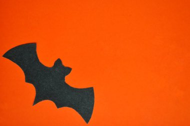 Siyah kağıt yarasa turuncu bir zeminde yatıyor.