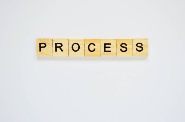 Kelime süreci. Beyaz arka planda harfleri olan tahta bloklar. Beyaz yüzeyde harfleri olan tahta blokların üst görünümü