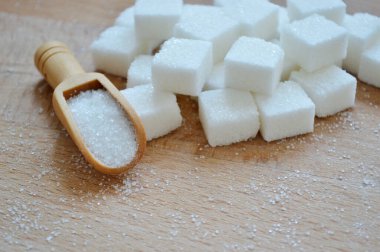 Rafine şeker ve ahşap zemin üzerinde gevşek şeker ile ahşap kaşık