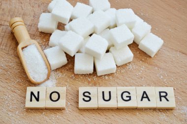 Rafine şeker ve ahşap arka planda bol şekerli ahşap kaşık. Tahta bloklardan ve harflerden oluşan şeker yok.