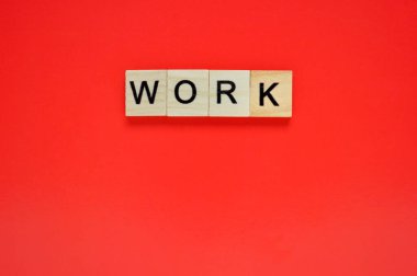 Kelime oyunu. Kırmızı arka planda harfleri olan tahta bloklar. Kırmızı yüzeyde harfleri olan tahta blokların üst görünümü