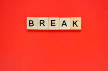 Sözüm söz. Kırmızı arka planda harfleri olan tahta bloklar. Kırmızı yüzeyde harfleri olan tahta blokların üst görünümü