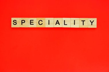 Kelime uzmanlığı. Kırmızı arka planda harfleri olan tahta bloklar. Kırmızı yüzeyde harfleri olan tahta blokların üst görünümü