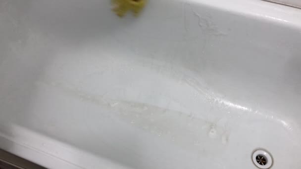 Mano in un guanto di gomma giallo lava il bagno con una spugna. — Video Stock