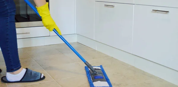 若い女性は台所でタイル張りの床をモップ洗浄 バナー — ストック写真