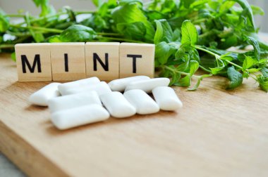 Bir sürü taze nane ve ahşap arka planda sakız.