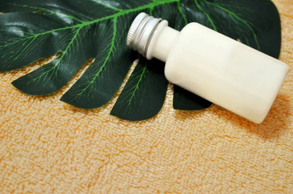 White Plastic Bottle Lies Palm Leaf Beige Cloth Background — Stock Photo, Image