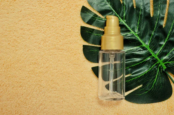 Transparente Plastikflasche Liegt Auf Einem Palmblatt Auf Beigem Stoff Hintergrund — Stockfoto
