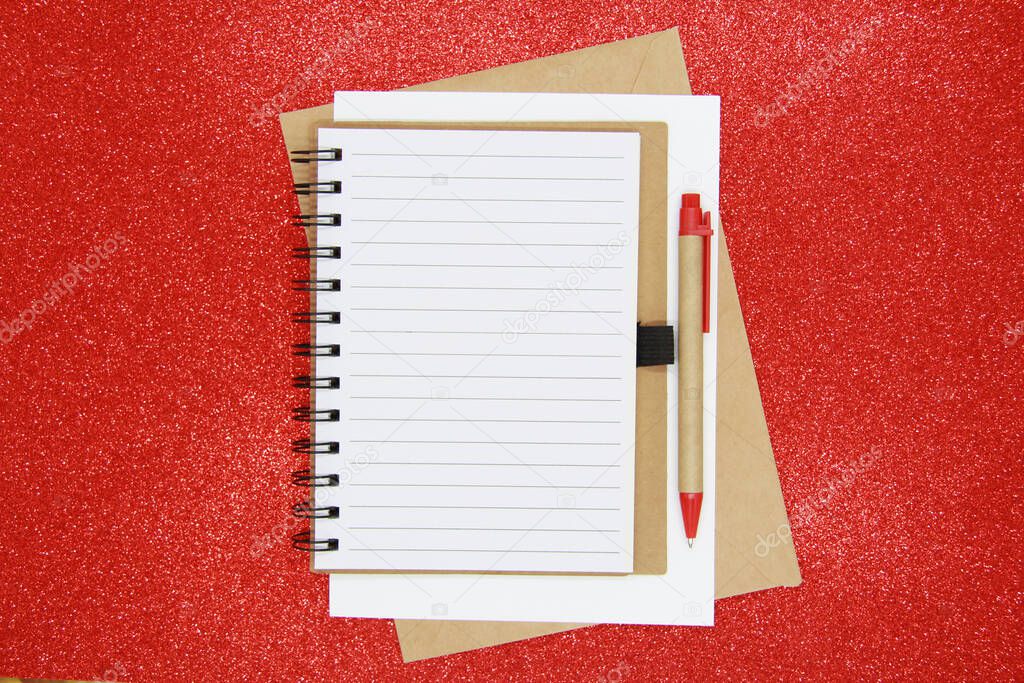 New year goal, plan, action text on Notepad with office accessories. Business motivation, concepts of inspiration. Notepad and pen, envelope on a shiny Red background. Flatly. The view from the top.