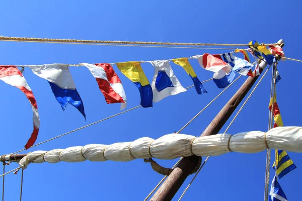 悬挂在桅杆上的海信号旗在蓝天的映衬下 进行了近距离拍摄 船旗在空中飘扬 摩斯密码 — 图库照片