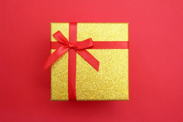 Goldene Geschenkschachtel Mit Roter Schleife Für Den Urlaub Auf Rotem — Stockfoto