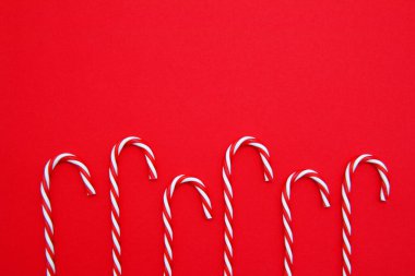 Noel zamanı. Kırmızı arka planda Noel şekeri kamışı. Noel zamanı. Yukarıdan manzara. Dümdüz. Kopyalama alanı.