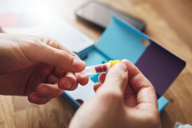 Test tüpü örneği tutan adamla yapılan ev kanı COVID-19 testi..