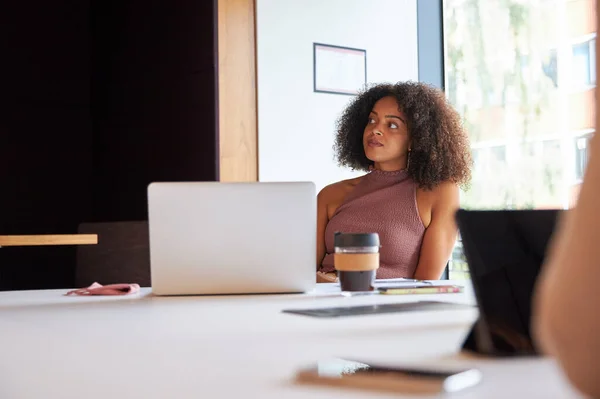 Businesswoman With Laptop At Socially Distanced Meeting In Office During Health Pandemic