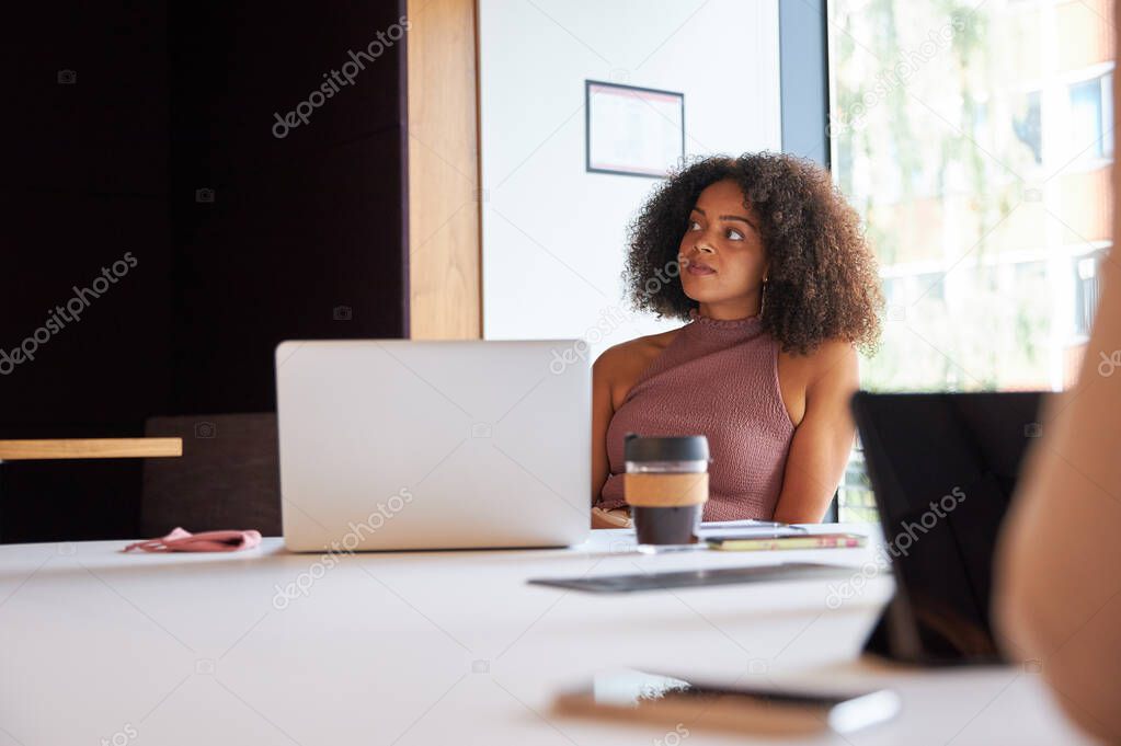 Businesswoman With Laptop At Socially Distanced Meeting In Office During Health Pandemic
