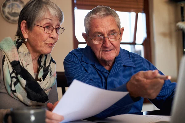 Senior Couple At Home Checking Personal Finances On Laptop