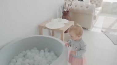 Küçük kız ile top oynarken. Bebek kalış topları ile havuz kenarında. Ağır çekim