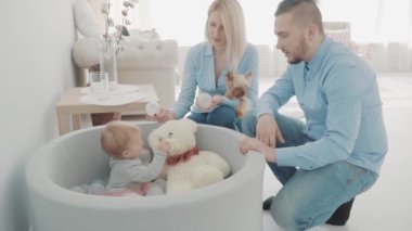 Mutlu anne ayı ve topları yakınındaki güzel kızı ile oynayan küçük köpek ile. Ağır çekim