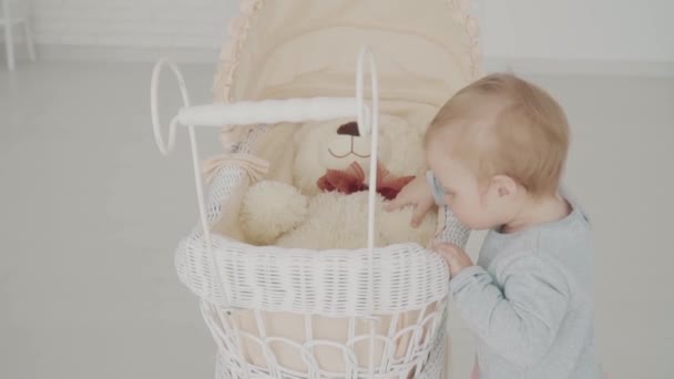 La niña toca al oso. A cámara lenta. Hito del bebé, niño, 1 año de edad. Feliz infancia. — Vídeos de Stock