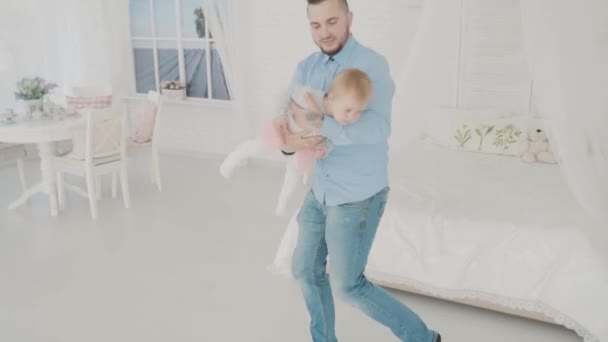 Otec, houpal jeho krásná dcera v místnosti. Zpomalený pohyb — Stock video
