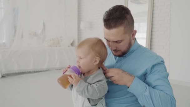 Längre klänningar hans vackra dotter på knä. Lycklig familj. Slow motion — Stockvideo