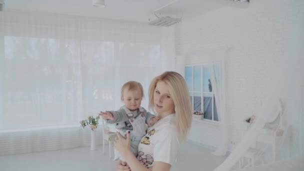 Mãe balançando sua linda filha no quarto. Família feliz. Movimento lento — Vídeo de Stock