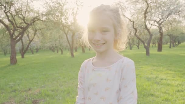 Portret krásná usměvavá dívka v parku. Slunce a procházku do přírody. Zpomalený pohyb — Stock video