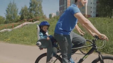 Genç küçük oğluyla daha uzağa park bir bisiklet sürme. Ağır çekim