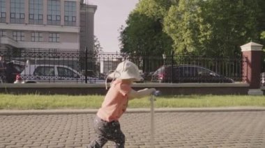 parkta tekme scooter üzerinde küçük tatlı çocuk. Ağır çekim