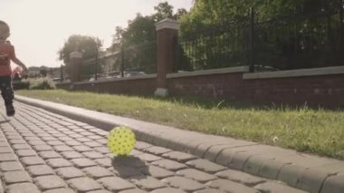 Topu parkta oynarken küçük güzel çocuk. Ağır çekim