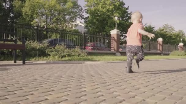 Pequeño niño hermoso jugando con la pelota en el parque. Movimiento lento — Vídeos de Stock