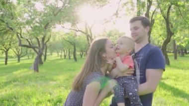 Mutlu anne pay onların şirin bebek çocuk Park'ta açık havada öp. Ağır çekim