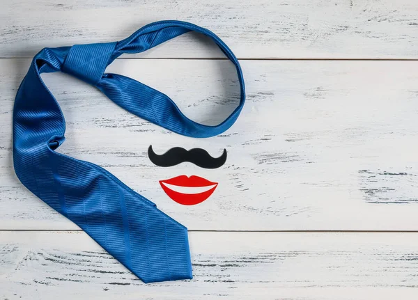 Niebieski Krawat Drewnianym Stole Niebieski Krawat Papierowe Wąsy Ustami Leżą — Zdjęcie stockowe