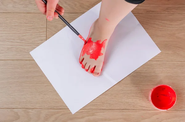 Children Leg White Piece Paper Hand Brush Paints Leg Red — Stock Photo, Image