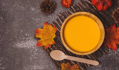 Balkabağı çorbası, arka planda balkabağı çorbası, sağda taştan bir zemin üzerinde, solda yazı için yer var, üstte yakın plan..