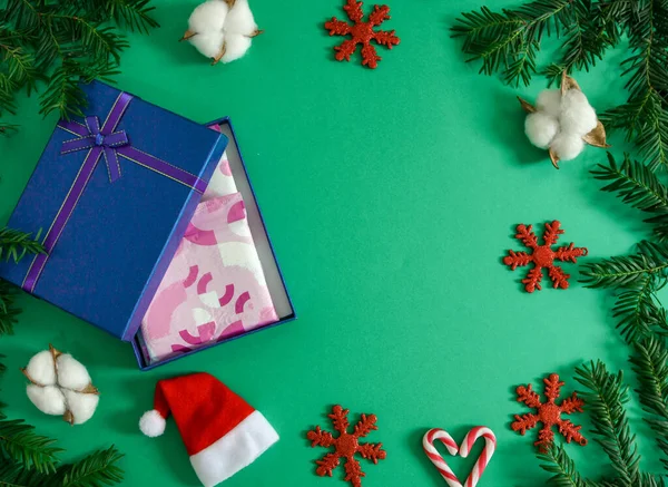Women  pads in a blue box.Female pads in a blue box with christmas decor on a green background and with a place for text on the right, top view close-up.