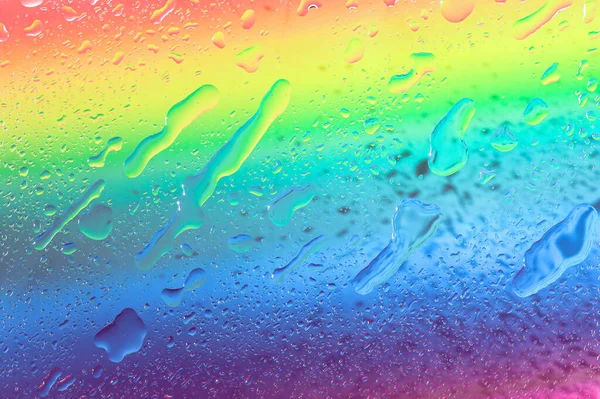 虹の背景に水滴虹の背景 テクスチャ 異なる形状の水滴 トップビューのクローズアップ — ストック写真