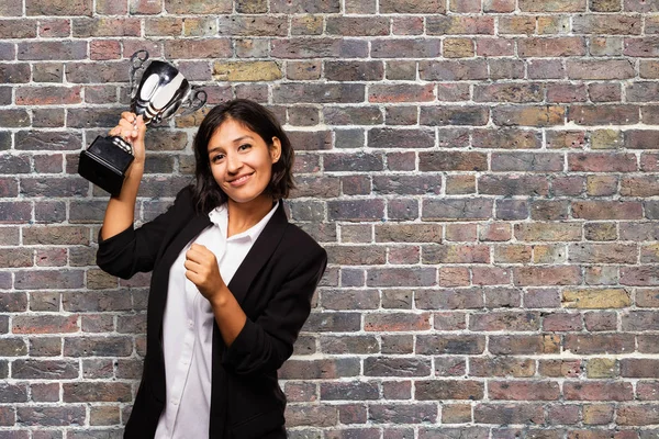 latin business woman holding a trophy