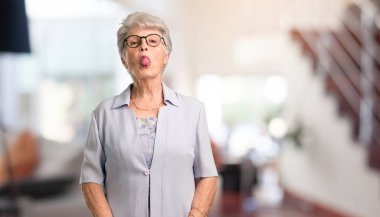 Güzel kadın kıdemli ifade güven ve duygu, eğlenceli ve dostu, dil oyun veya eğlenceli evde bir işareti olarak gösterilen.