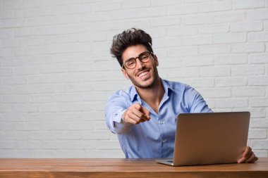 Genç iş oturan ve bağırarak, gülen ve başka bir, kavramı alay alay bir dizüstü bilgisayarda çalışan adam ve uncontrol