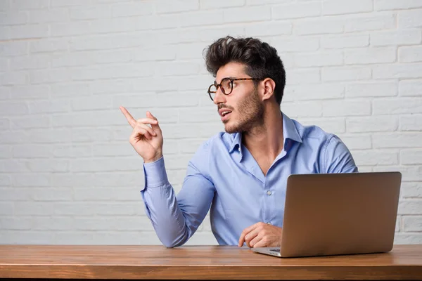 Young Business Man Sitting Working Laptop Pointing Side Smiling Surprised — Stock Photo, Image