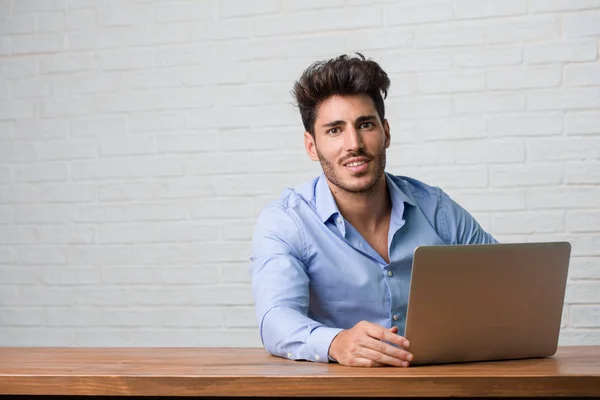 Ung Forretningsmann Som Sitter Jobber Bærbar Med Hender Hoftene Står – stockfoto