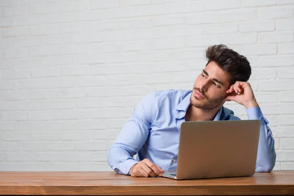 Giovane Uomo Affari Seduto Lavoro Computer Portatile Guardando Alto Pensando — Foto Stock